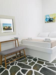 1 dormitorio con cama, mesa y taburete en Onar studios & residences, en Pisses