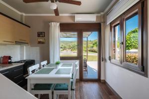 eine Küche und ein Esszimmer mit einem Tisch und einem Fenster in der Unterkunft Arteon Villas in Agios Nikolaos