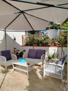 a patio with wicker chairs and a white table at La pomelia in Casa Di Natale
