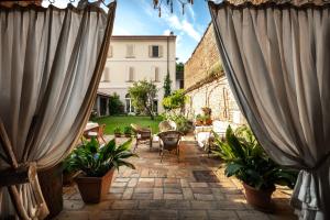 a patio with two large curtains and plants at La Casa nel Borgo in Piadena