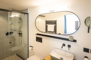 a bathroom with a shower and a sink and a mirror at Hotel zum Löwen in Weißenhorn