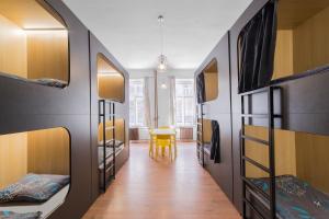 a room with a hallway with bunk beds and a table at Hostel Elf in Prague