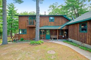 ein Holzhaus mit einer Veranda und einem Baum in der Unterkunft Lakeview Lookout in Wisconsin Dells