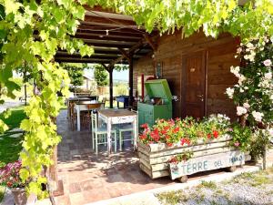 a patio with a table and chairs and flowers at Terre del Piano-Bell Tent in Corinaldo