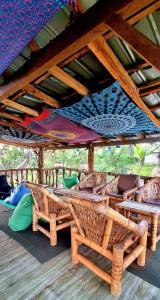 a large wooden table and chairs under a roof at Tetebatu Sama Sama Bungalows in Tetebatu