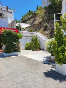 a house with a white fence and some trees at Pension los Verdiales in La Herradura