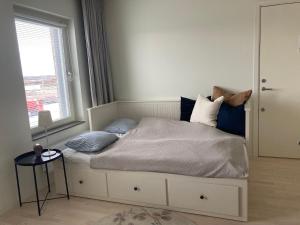 una camera da letto con letto, cuscini e finestra di Hyllie Appartement - New Construction a Malmö