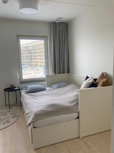 Schlafzimmer mit einem großen Bett und einem Fenster in der Unterkunft Hyllie Appartement - New Construction in Malmö