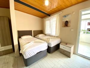 1 dormitorio con 2 camas y ventana en Emir Pansiyon, en Marmara