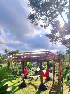 a wooden structure with hammocks under a tree at Tetebatu Sama Sama Bungalows in Tetebatu