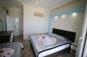 a bedroom with a bed with red flowers on it at Deniz Hotel in Finike