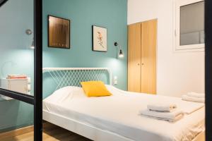 een slaapkamer met een bed met een geel kussen bij Chill in condo next Kalimarmaro! in Athene