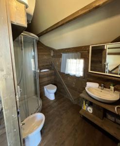 a bathroom with two sinks and a shower and a toilet at Terre del Piano in Corinaldo