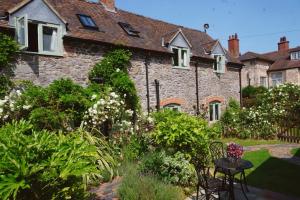 einen Garten vor einem Steinhaus in der Unterkunft Nest Holiday Hideaway Wren Cottage Stunning Area! in Church Stretton