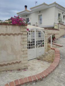 a gate to a house with pink flowers at Cruzeto in Syvota