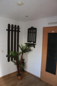 een kamer met een muur met een plant en een deur bij Pension Lehmann in Köthen