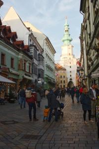 um grupo de pessoas andando por uma rua da cidade em Old town 1 bdr, A/C, w/parking em Bratislava