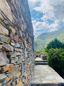 a stone building with a stone wall at Onar studios & residences in Pisses