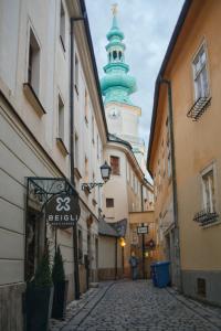 an alley with a building with a clock tower at Old town 1 bdr, A/C, w/parking in Bratislava