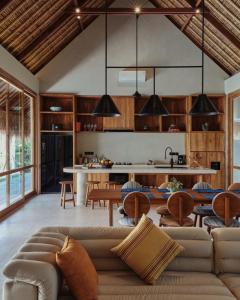 a living room with a couch and a kitchen at Boni Beach Lombok Boutique Hotel in Selong Belanak