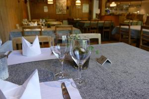 two wine glasses sitting on a table in a restaurant at Landgasthof Tännler in Innertkirchen