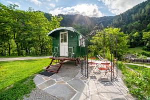 een groen tiny house met een tafel en stoelen bij Camping Passeier Glamping Tilia in Saltusio