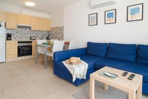 a living room with a blue couch and a table at Sabbia Suites Pleamar in Puerto del Carmen +22 photos