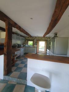 a large kitchen with a counter in a room at Maison en pierre dans son nid de verdure in Roz-Landrieux