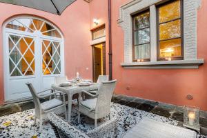 eine Terrasse mit einem Tisch und Stühlen vor einem Haus in der Unterkunft Casa Vera, exquisite 2 bedrooms 2 baths apartment with garden, A/C, close to Parking in Lucca