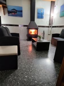 a living room with a fireplace and a couch at Pension los Verdiales in La Herradura
