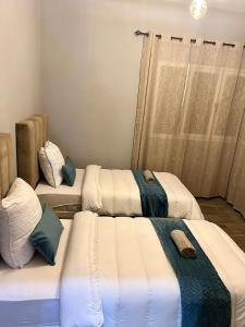 un grupo de 3 camas en una habitación en Haut Standing VILLA OUJDA, en Oujda