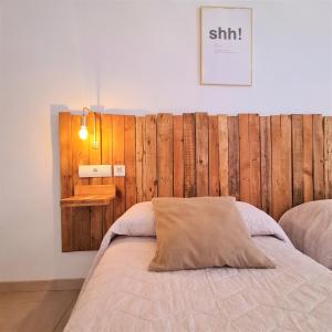 a bedroom with a bed with a wooden wall at Tabbu ibiza apartments in Playa d'en Bossa