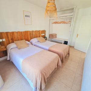 a bedroom with two beds and a mirror at Tabbu ibiza apartments in Playa d'en Bossa +37 photos