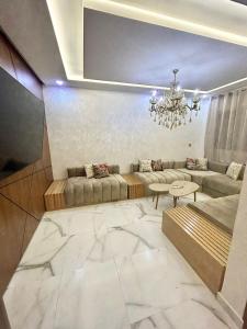 sala de estar con sofá y lámpara de araña en Haut Standing VILLA OUJDA, en Oujda