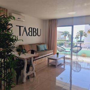 a living room with a couch and a table at Tabbu ibiza apartments in Playa d'en Bossa