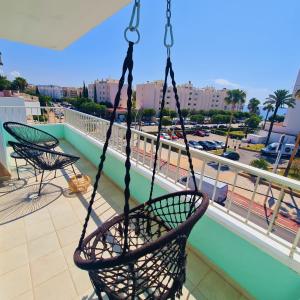 a swing on a balcony with a view of a city at Tabbu ibiza apartments in Playa d'en Bossa