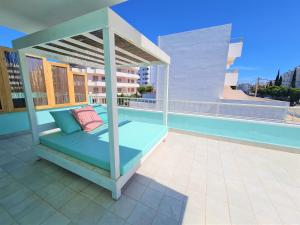 a bed on the roof of a balcony at Tabbu ibiza apartments in Playa d'en Bossa