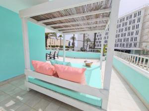 a balcony with a bed with pillows on it at Tabbu ibiza apartments in Playa d'en Bossa