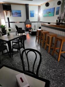 a restaurant with tables and chairs and a fireplace at Pension los Verdiales in La Herradura
