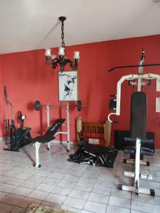 a gym with a red wall and some exercise equipment at Parada 86 Hostel in Sao Paulo