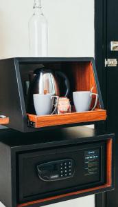 a microwave with two cups on top of it at S Loft Manado in Manado