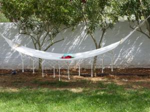 a white hammock hanging from trees in a yard at Villa Alexia in Souda