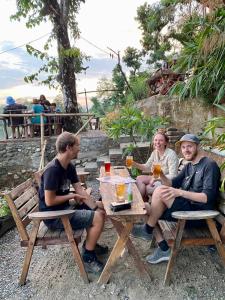 un grupo de personas sentadas en una mesa con bebidas en Happy Lemon Tree lodge en Sauraha