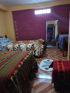 um quarto com duas camas e uma parede roxa em El Amauta de los Andes Lodging Erik House em Huaraz