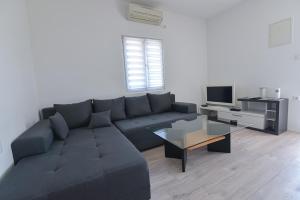 een woonkamer met een bank en een tafel bij Brseč Villa AnDa s apartmanima i bazenom in Brseč