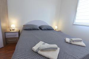 een slaapkamer met een bed met handdoeken erop bij Brseč Villa AnDa s apartmanima i bazenom in Brseč +54 foto's