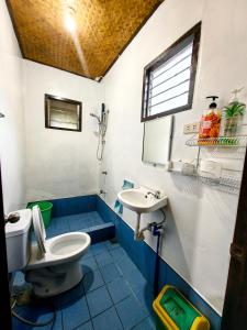 uma casa de banho com um WC e um lavatório em Besaga Beachfront B&B - Port Barton em San Vicente