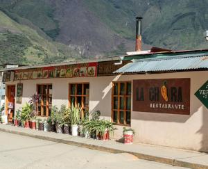 a restaurant with plants in front of a building at mini-hogar en santa teresa in Santa Teresa