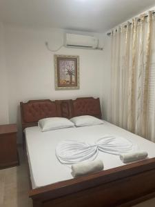 sypialnia z dużym łóżkiem z białą pościelą w obiekcie Apartments Hidri w Ulcinju
