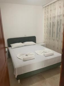 sypialnia z łóżkiem z dwoma ręcznikami w obiekcie Apartments Hidri w Ulcinju